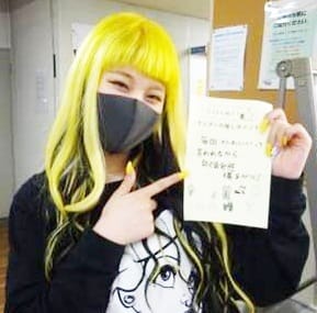 笑顔でメモを見せている女子