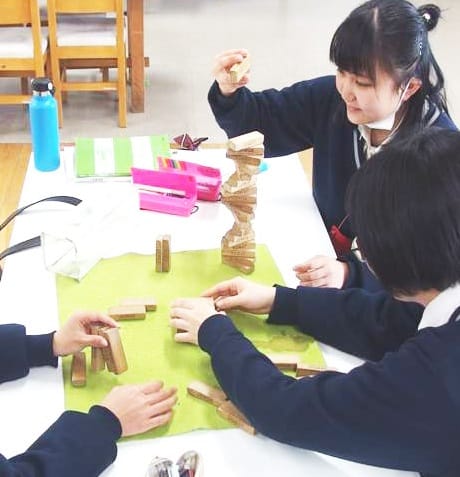 制服で積み木をしている女性３人